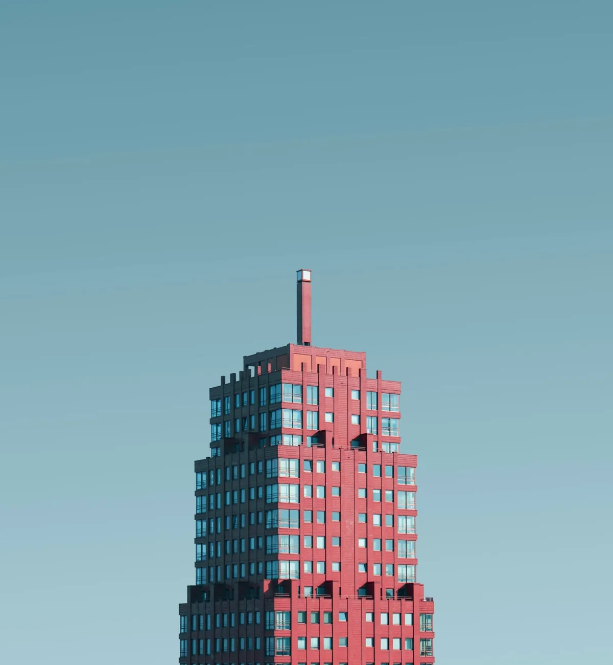 Red high-rise tower against a clear sky