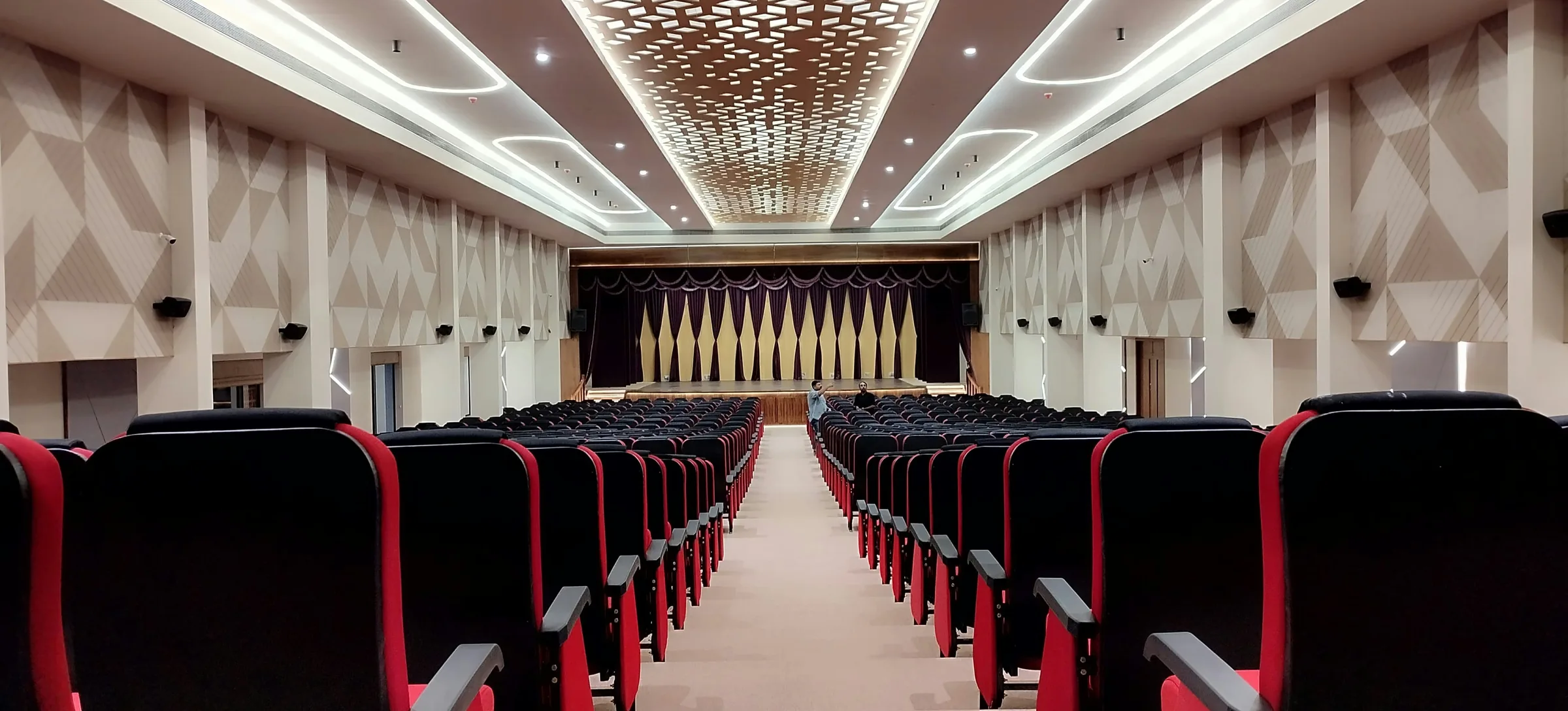 Empty auditorium with rows of seats facing a lit stage
