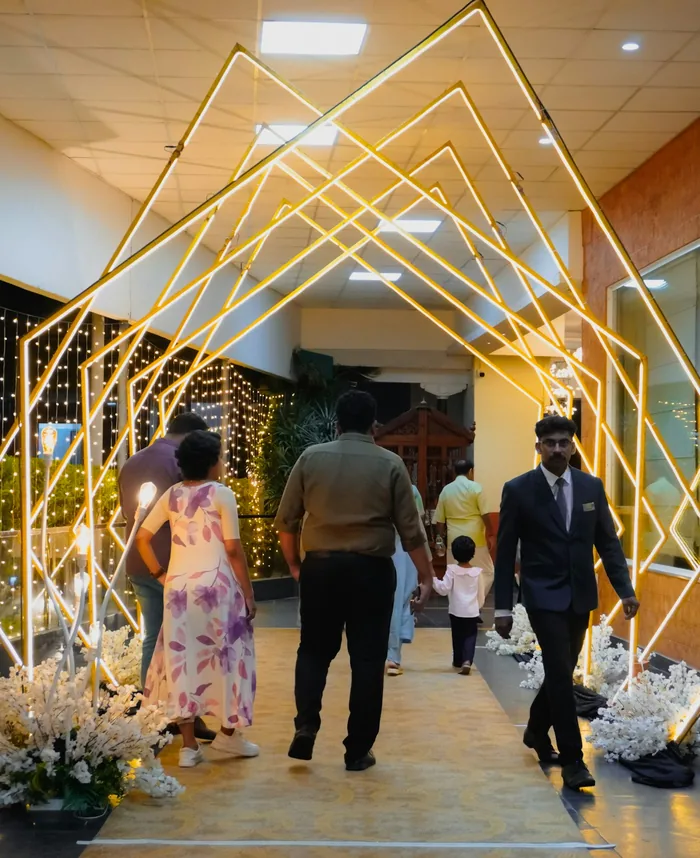 Guests walking through an entrance of glowing geometric light frames