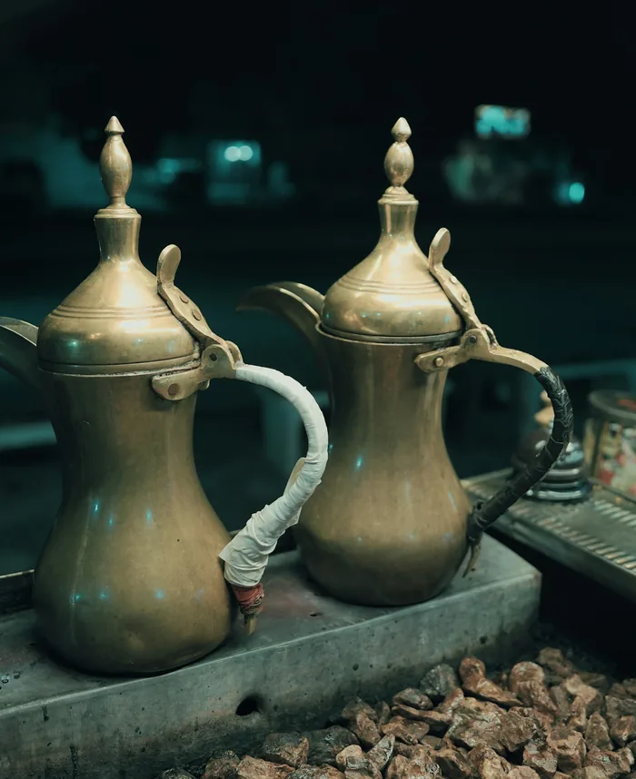 Two brass Arabic coffee pots on a metal tray