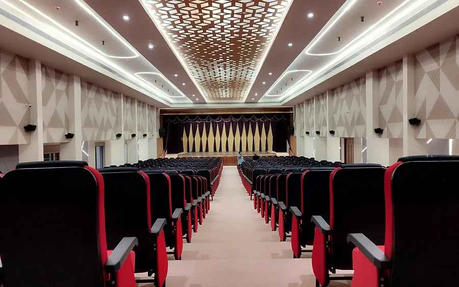 Empty auditorium with rows of seats facing a lit stage